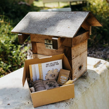 Load image into Gallery viewer, Bird house with a Seed Kit sitting on a table outside.