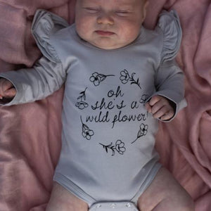 oh-she's-a-wildflower-onesie-on-a-sleeping-baby-girl