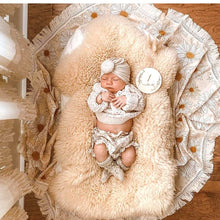Load image into Gallery viewer, newborn baby lying on a sheepskin rug and daisy blanket