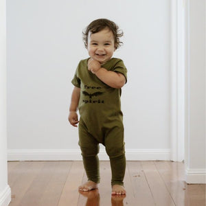 toddler boy smiling wearing an olive jumpsuit