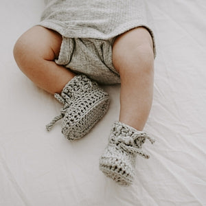 baby-legs-and-torso-wearing-grey-romper-and-booties