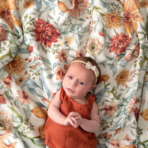 baby-girl-laying-on-floral-baby-blanket