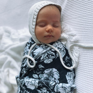 baby-asleep-wearing-a-bonnet-and-swaddled